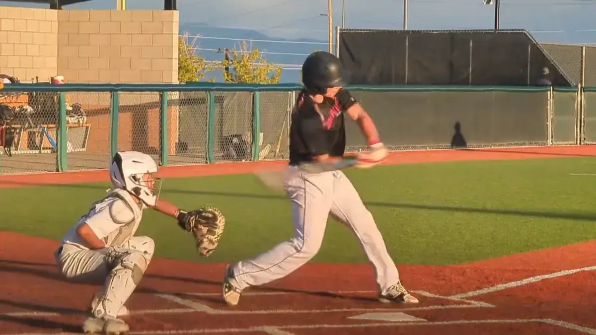 The same hitter driving through the zone with his front side braced and head on the ball