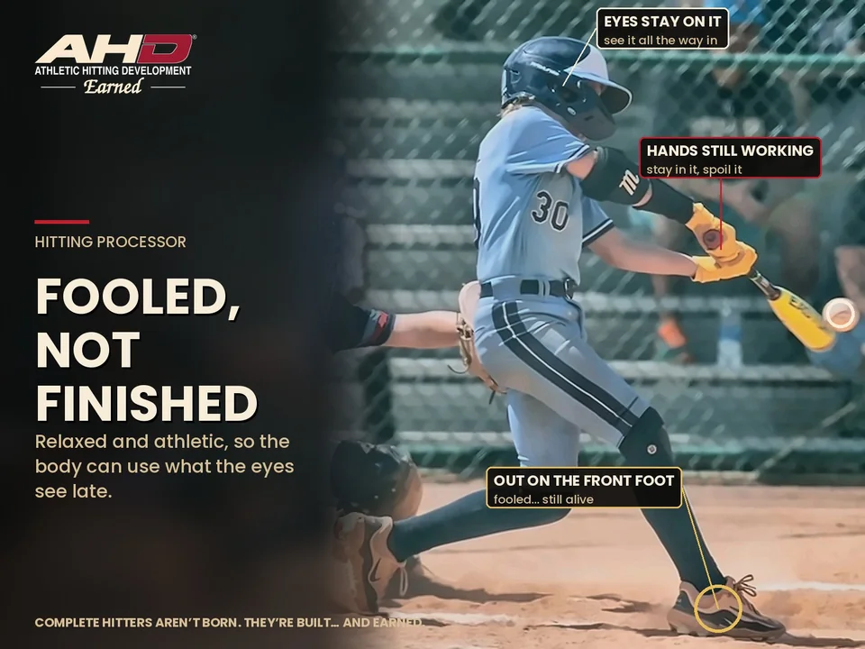 AHD fastpitch hitter out on her front foot in a game, hands still working and eyes on the ball, battling to stay alive in the at-bat