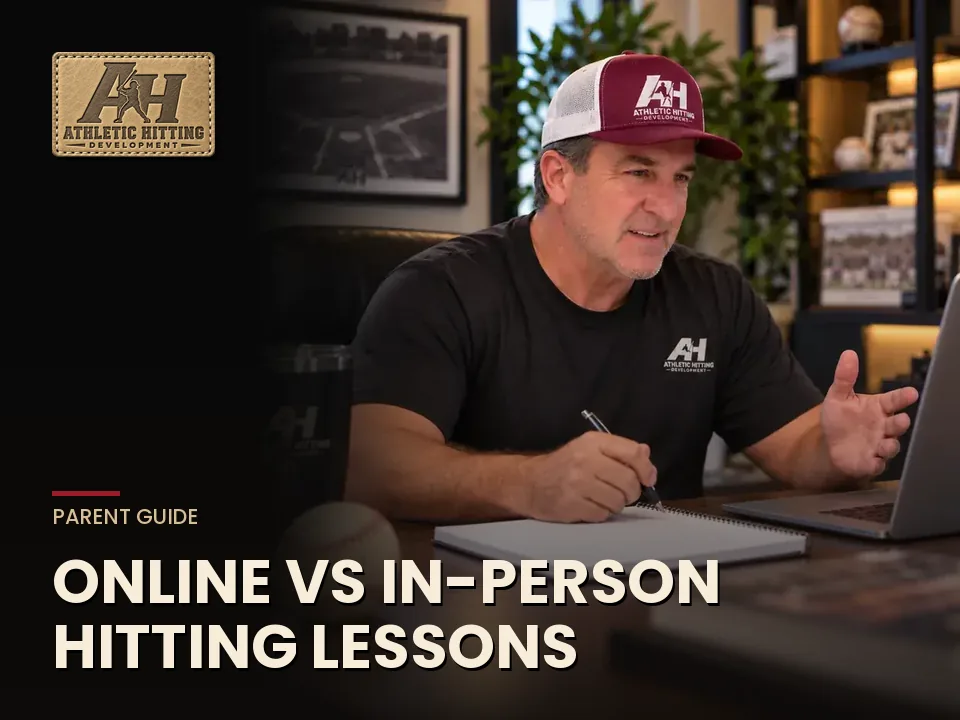 Coach reviewing a hitter's swing video on a laptop for an online lesson
