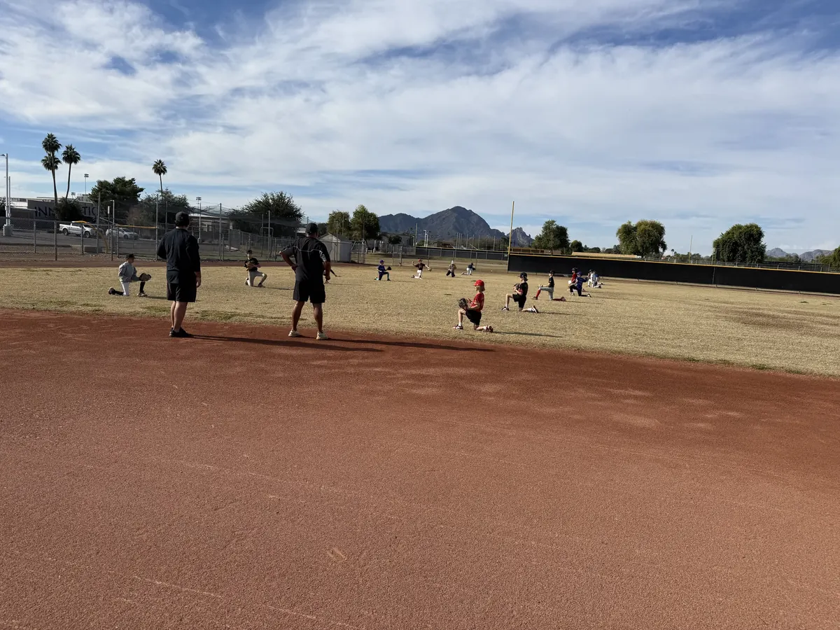 AHD coaches watching throwing warm-ups, Camelback Mountain in the distance